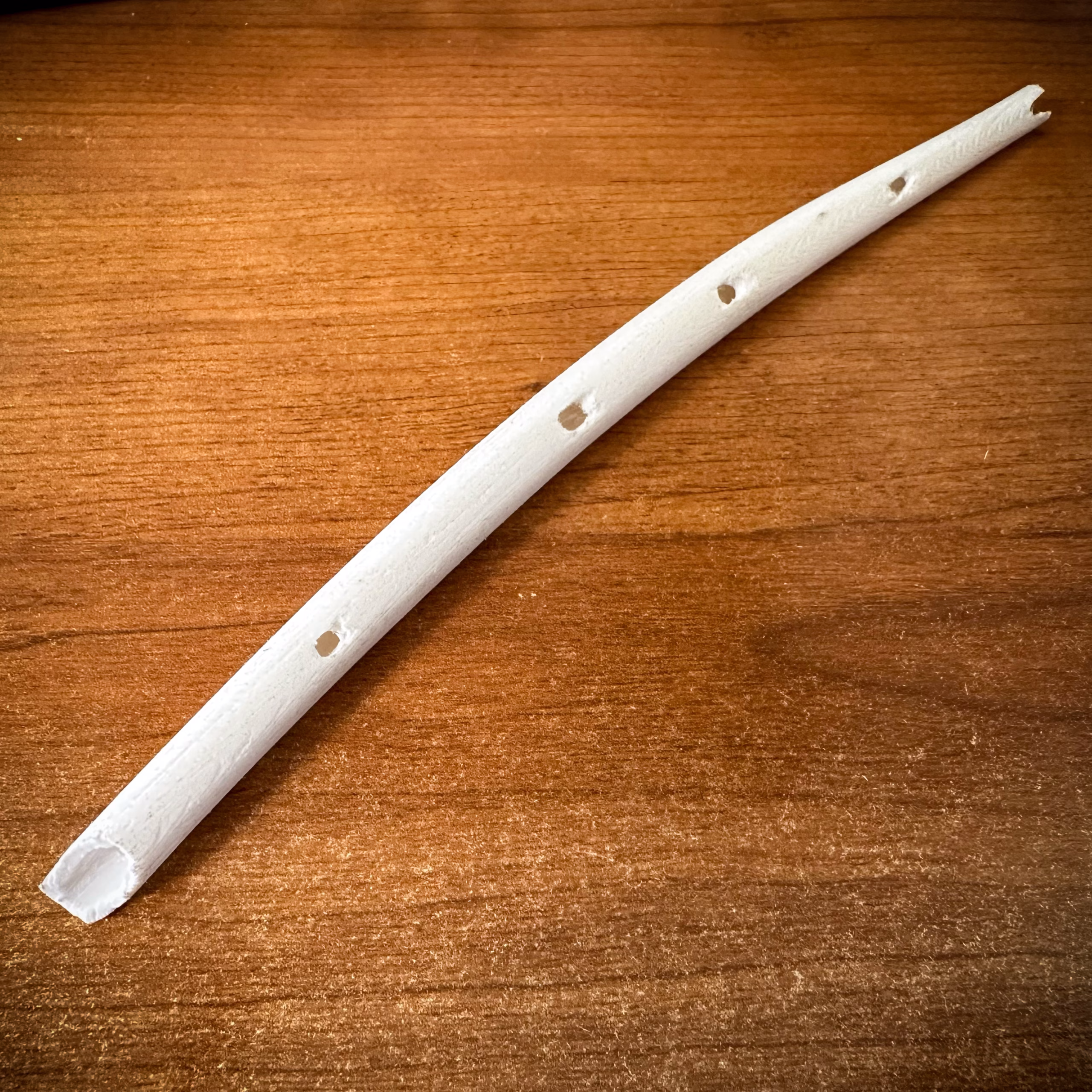 Hohle Fels flute replica resting on a wooden desk